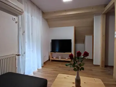 a living room with a vase with roses on a table at Apartmaji Mojca in Bohinj