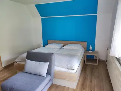 a bedroom with a bed and a blue wall at Apartmaji Mojca in Bohinj