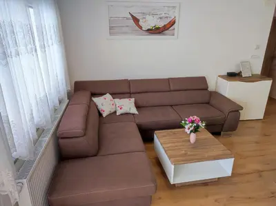 a living room with a brown couch and a table at Apartmaji Mojca in Bohinj
