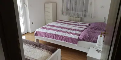 a bedroom with two beds with purple and white blankets at Apartma Čeh in Gabrovica pri Črnem Kalu