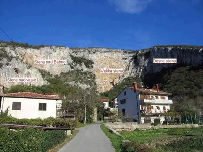 a road in front of a mountain with signs on it at Apartma Čeh in Gabrovica pri Črnem Kalu