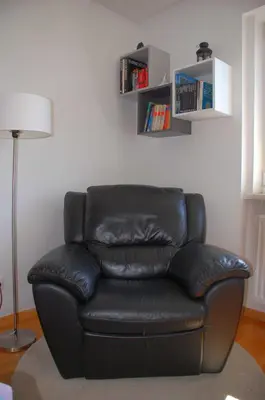 a black leather couch sitting in a living room at Apartments Peter & Free parking in Ljubljana