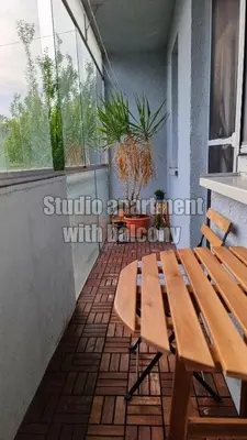 a wooden table and chairs on a balcony at Apartments Peter & Free parking in Ljubljana