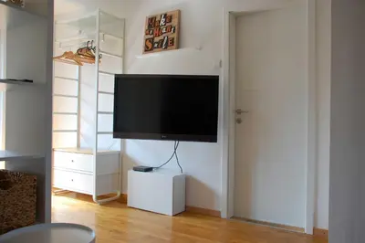 a living room with a flat screen tv on a wall at Apartments Peter & Free parking in Ljubljana
