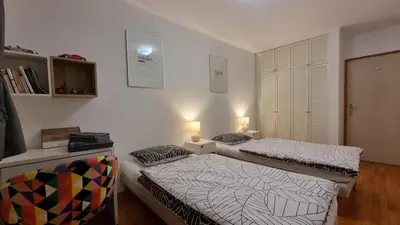 two beds in a room with two lamps on them at Apartments Peter & Free parking in Ljubljana