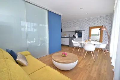 a living room with a yellow couch and a table at Apartmaji 43 in Tolmin