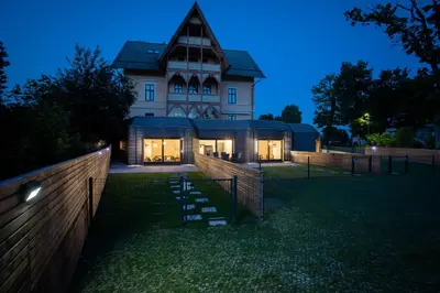 a large house with a fence in front of it at Tamara Luxury Apartments in Bled