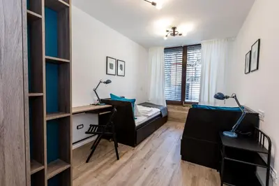 a bedroom with a bed and a desk and a bed and shelves at Tamara Luxury Apartments in Bled
