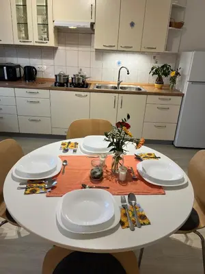 a white table in a kitchen with plates and utensils at Apartments Bukor with seasonal pool in Lukovica pri Domžalah