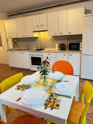 a kitchen with a table with plates and flowers on it at Apartments Bukor with seasonal pool in Lukovica pri Domžalah