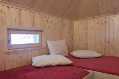 a bedroom with two pillows and a window at Koča Predilnica Velika Planina in Kamniška Bistrica