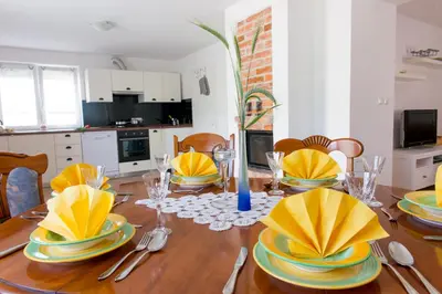 a dining room table with yellow and blue dishes on it at Apartma Marija in Metlika