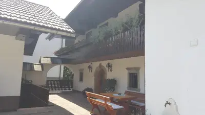 a house with a table and a bench in a courtyard at Apartments Dolar in Bled