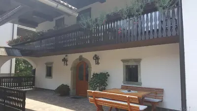a house with a wooden table and a balcony at Apartments Dolar in Bled