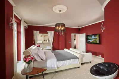 a bedroom with red walls and a bed and a table at Karavla Private Villa in Šentilj