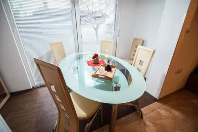 a glass table with chairs and a cake on it at Apartments Ole in Tolmin