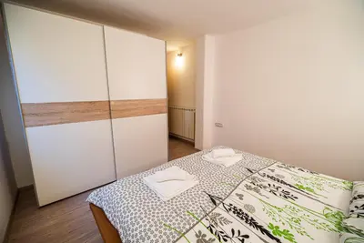a small bedroom with a bed and a closet at Apartments Ole in Tolmin