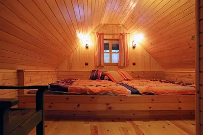 a bed in a wooden room in a log cabin at Natural Wooden Sweetheart in Padeški Vrh