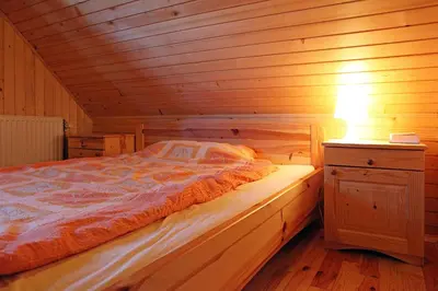 a bedroom with a bed in a wooden cabin at Natural Wooden Sweetheart in Padeški Vrh