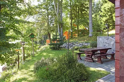 a picnic table in a garden with trees and grass at Natural Wooden Sweetheart in Padeški Vrh