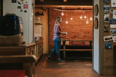 a woman standing in front of a brick wall at Hostel Lukna in Mojstrana