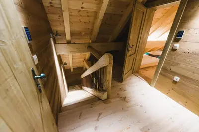 an inside view of a wooden room with a door at Hostel Lukna in Mojstrana