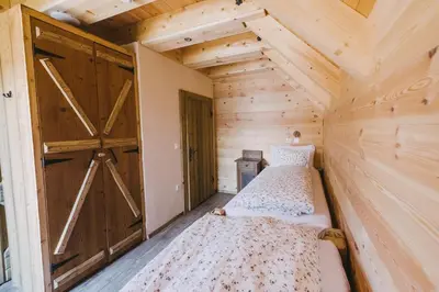 two beds in a room with a barn door at Hostel Lukna in Mojstrana