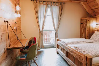 a bedroom with two beds and a window at Hostel Lukna in Mojstrana