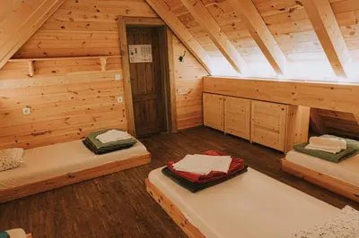 a room with two beds in a log cabin at Hostel Lukna in Mojstrana