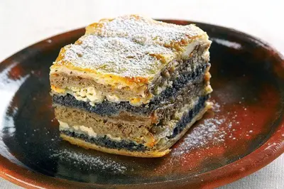 a piece of cake on a plate with powdered sugar at Apartment Maja Moravske Toplice in Moravske Toplice