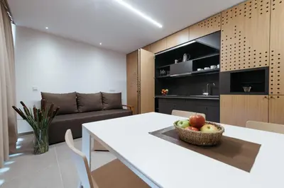 a kitchen and living room with a table and a couch at Hotel Ajda Depandance Prekmurska Vas - Terme 3000 - Sava Hotels & Resorts in Moravske Toplice