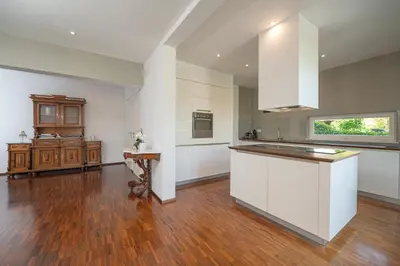 a large kitchen with white cabinets and a wooden floor at Luxury Apartment Nana in Bled