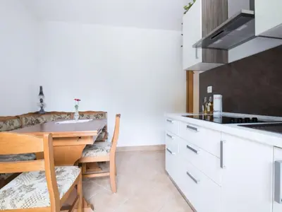 a kitchen with a table and a counter top at Apartma Matajurc in Trnovo ob Soči