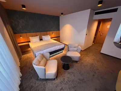 a hotel room with a bed and a couch and chairs at Terme Paradiso - Hotel Paradiso in Dobova