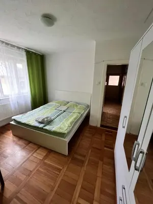a bedroom with a bed and a wooden floor at Rooms & Apartments MURGLE Ljubljana in Ljubljana