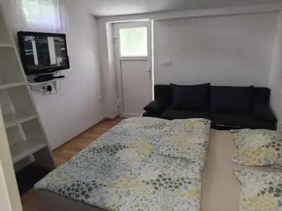 a living room with a couch and a flat screen tv at Rooms & Apartments MURGLE Ljubljana in Ljubljana