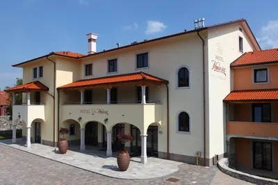 a large white building with red roof at Hotel Malovec in Divača