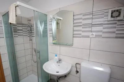a bathroom with a sink and a toilet and a mirror at Apartments Furman - SELF CHECK-IN in Rakek