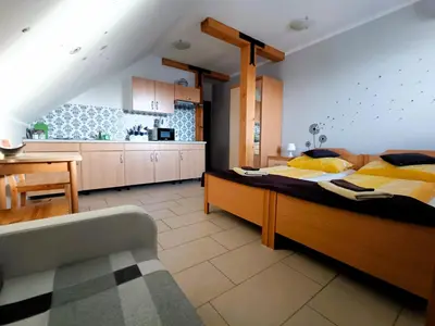 a bedroom with a large bed and a kitchen at Apartments Furman - SELF CHECK-IN in Rakek