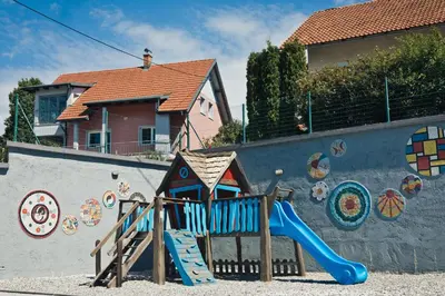 a playground with a slide in front of a wall at Apartments Furman - SELF CHECK-IN in Rakek