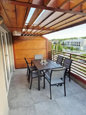 a dining table and chairs on a balcony with a view at Apartment Paradise in Moravske Toplice