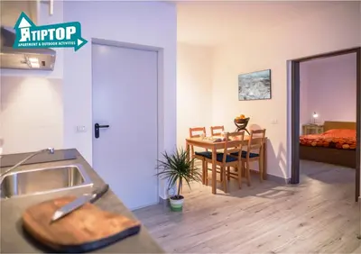 a kitchen and a dining room with a table at Tiptop Apartment & Outdoor Activities in Bovec