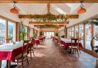 a restaurant with tables and chairs and windows at Tiptop Apartment & Outdoor Activities in Bovec