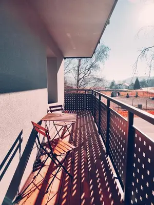 a wooden table and chair sitting on a balcony at Apartments & rooms Saša in Podčetrtek
