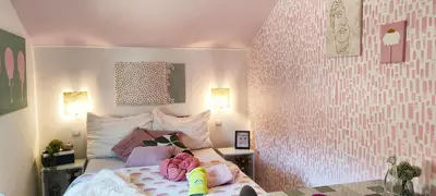 a bedroom with a large bed with pink walls at Apartments & rooms Saša in Podčetrtek