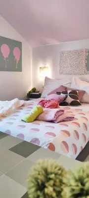 a bedroom with a bed with colorful pillows on it at Apartments & rooms Saša in Podčetrtek