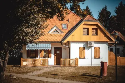 a house with an orange roof and a fence at POČITNIŠKI APARTMAJI - Sunny apartment in Moravske Toplice in Moravske Toplice