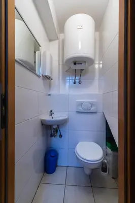 a white bathroom with a toilet and a sink at POČITNIŠKI APARTMAJI - Sunny apartment in Moravske Toplice in Moravske Toplice