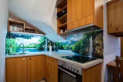 a kitchen with a waterfall mural on the wall at POČITNIŠKI APARTMAJI - Sunny apartment in Moravske Toplice in Moravske Toplice