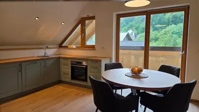 a kitchen with a table and chairs and a window at Domačija Loncnar in Bohinj